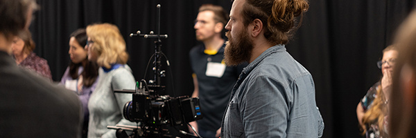 People standing around a high specification video camera in the XR Stories immersive technology lab.