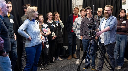 Participants on the XR Accelerator programme stand in the XR Stories immersive technology lab, a cutting edge studio in The Guildhall, York watching members of the XR Stories team demonstrate video camera and motion capture equipment